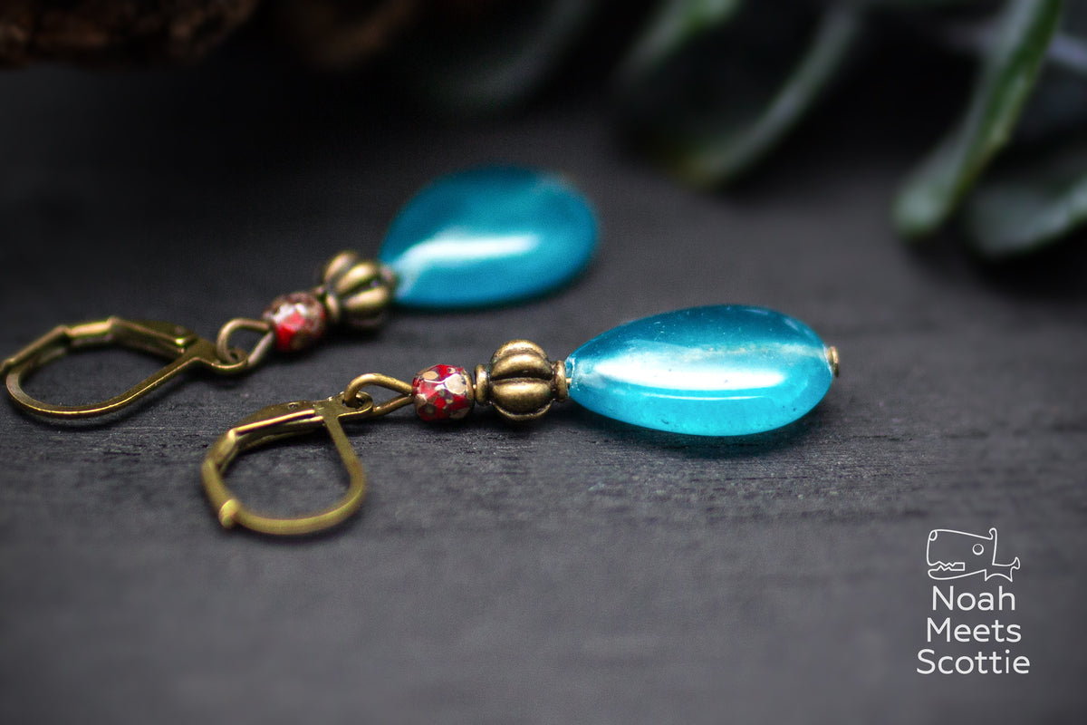 Tropfen Ohrringe in kräftigem Türkis, Rot und Antikbronze mit einer Gesamtlänge von etwa 4 cm.