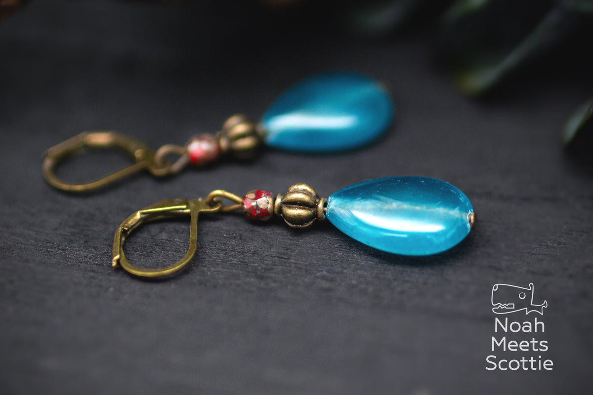 Vintage Ohrhänger in Türkis und Bronze mit tropfenförmiger Perle und kleinem rot gemustertem Akzent.