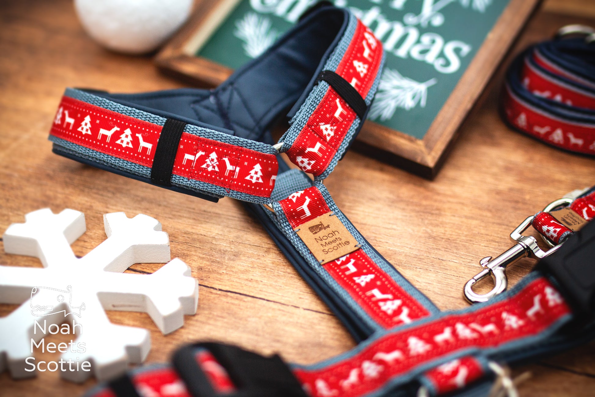 Nahaufnahme des roten Hundegeschirrs mit weißen Rentieren, Tannen und geometrischen Elementen wie auf einem nordischen Weihnachtspullover.