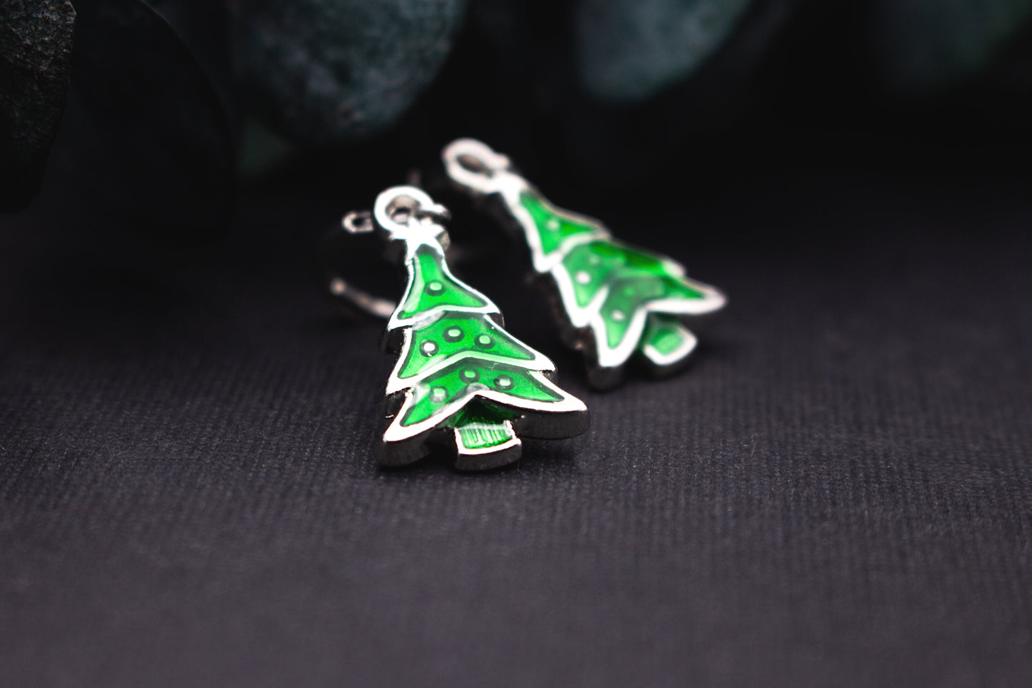 Grüne Emaille-Tannenbaum-Ohrringe mit silbernem Rand – moderner, winterlicher Ohrschmuck für Weihnachtszeit und festliche Outfits.