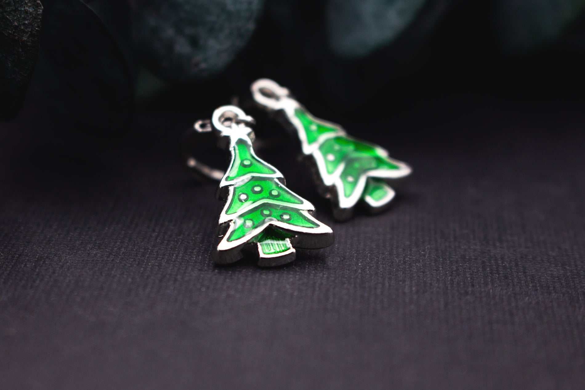 Grüne Emaille-Tannenbaum-Ohrringe mit silbernem Rand – moderner, winterlicher Ohrschmuck für Weihnachtszeit und festliche Outfits.